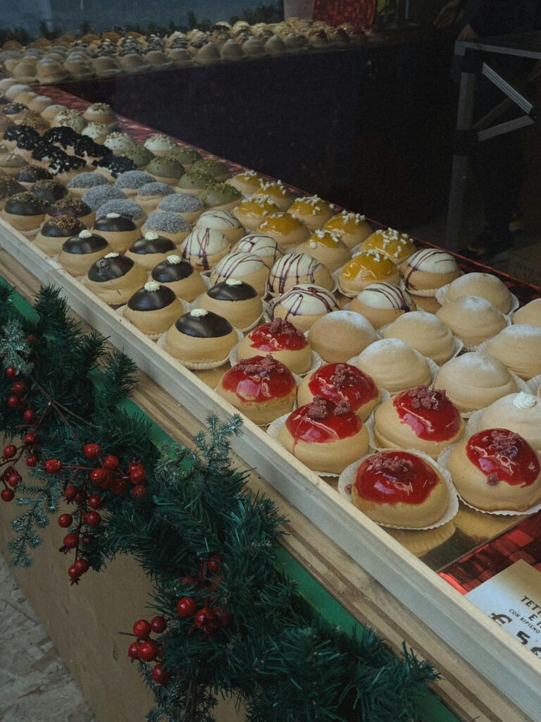 A vibrant display of assorted pastries with holiday decorations in a bakery.